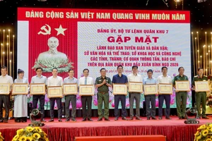 Đại diện Báo Nhân Dân tại khu vực miền Nam (thứ tư từ trái sang) nhận bằng khen từ Bộ Tư lệnh Quân khu 7. 