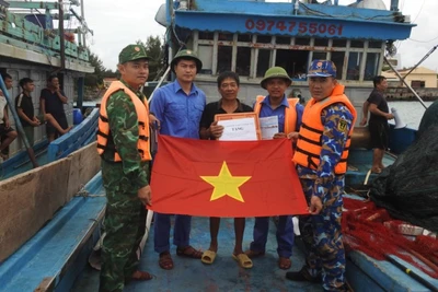 Cán bộ, chiến sĩ đảo Đá Tây thăm hỏi tặng cờ Tổ quốc cho ngư dân vào tránh trú bão