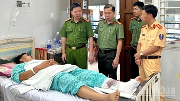 Đại tá Nguyễn Tường Vũ (bên trái) đến thăm hỏi, động viên Trung tá Nguyễn Hoàng Trung đang điều trị tại Bệnh viện Chấn thương chỉnh hình Thành phố Hồ Chí Minh.
