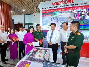 Các đại biểu tham quan gian hàng của doanh nghiệp trưng bày ứng dụng chuyển đổi số.
