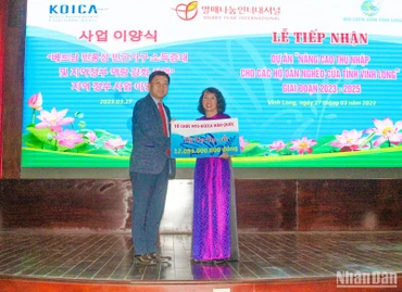 Đại diện Tổ chức Merry Year International (Hàn Quốc) trao bảng tượng trưng hỗ trợ dự án. 