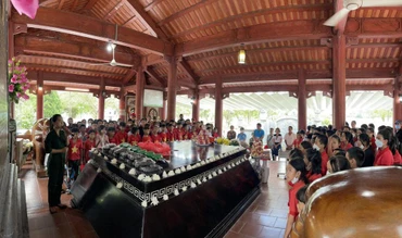 Du khách tham quan, tìm hiểu nhiều hình ảnh tư liệu về Bác Hồ, về quan hệ Việt-Lào được trưng bày tại khuôn viên Khu di tích Kim Liên. (Ảnh: THU THỦY)