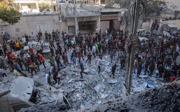 Người dân Palestine đứng giữa đống đổ nát của những tòa nhà bị phá hủy sau đòn không kích của Israel tại khu vực Al-Rimal, phía tây thành phố Gaza ngày 30/8/2025. (Ảnh: THX/TTXVN)