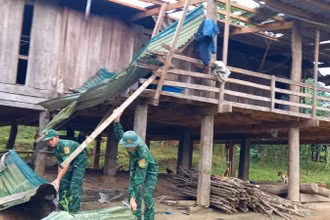Cán bộ, chiến sĩ Đồn Biên phòng Ra Mai giúp bà con lợp lại nhà bị lốc xoáy làm hư hỏng.