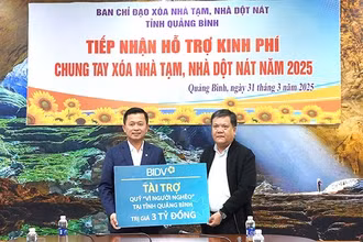 Chủ tịch Ủy ban nhân dân tỉnh Quảng Bình Trần Phong (bên phải) tiếp nhận hỗ trợ của BIDV để xóa nhà tạm, nhà dột nát cho hộ nghèo