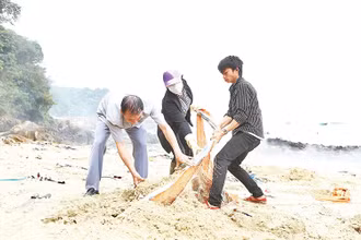 Người dân Cô Tô tham gia thu gom rác làm sạch bãi biển.