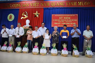 Anh Nguyễn Văn Dũng (giữa) tặng quà các nạn nhân chất độc màu da cam. Ảnh: Công Thi