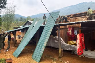 Lực lượng dân quân tự vệ và thanh niên hỗ trợ người dân sửa chữa lại nhà cửa.