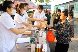 Y, bác sĩ trong đoàn công tác Bộ Y tế trao thuốc cho người dân nghèo tỉnh Điện Biên.