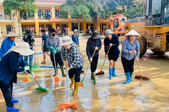 Giáo viên cùng các phụ huynh học sinh trường Minh Chuẩn, huyện Lục Yên vệ sinh sân trường sau bão số 3. (Ảnh: THANH SƠN)
