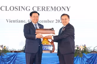 Chủ tịch Quốc hội Vương Đình Huệ nhận búa đảm nhận chức Chủ tịch Hội nghị cấp cao Quốc hội ba nước CLV lần thứ hai từ Chủ tịch Quốc hội nước Lào Saysomphone Phomvihane. (Ảnh: TTXVN)