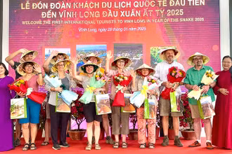 Lãnh đạo tỉnh Vĩnh Long tặng quà và hoa cho khách du lịch quốc tế đầu tiên. 