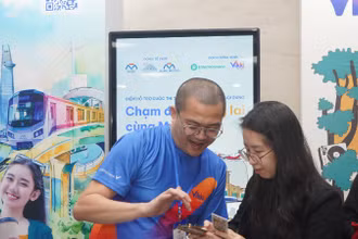 Nhân viên Ngân hàng hỗ trợ hành khách làm thẻ đi Metro số 1 miễn phí tại các nhà ga trên hành trình. (Ảnh: Thế Anh) 