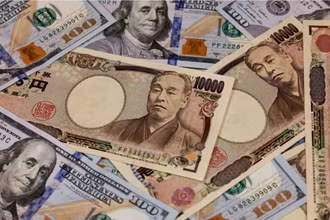 Đồng 10.000 yen và đồng 100 USD. Ảnh: AFP/TTXVN.