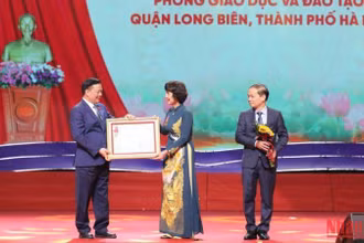 Đồng chí Đinh Tiến Dũng trao Huân chương Lao động hạng Nhất cho Phòng Giáo dục và Đào tạo quận Long Biên. (Ảnh: THANH TÙNG) 