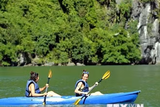 Du khách trải nghiệm chèo thuyền kayak, thuyền tay trên Vịnh Hạ Long. (Ảnh: Thanh Vân/TTXVN)