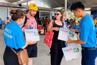 Đoàn công tác huyện Cô Tô tuyên truyền và cung cấp túi giấy thay thế túi nilon cho du khách trong giai đoạn đầu thí điểm. (Ảnh: Trung tâm Thông tin-Văn hóa huyện Cô Tô) 