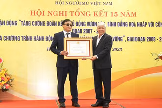 Đồng chí Đỗ Văn Chiến trao Huân chương Lao động hạng Ba tặng ông Phạm Xuân Trường, Ủy viên Ban Thường vụ Hội Người mù Việt Nam, với những đóng góp vì người mù. (Ảnh: mattran.org.vn)