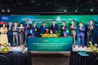 Đại diện lãnh đạo hai ngân hàng trao đổi văn kiện chứng nhận hoàn tất thương vụ phát hành cổ phiếu riêng lẻ.