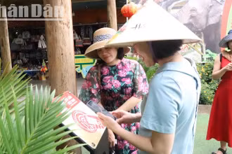 Du khách phấn khởi khi trải nghiệm tìm hiểu về Trung tâm Du lịch Cầu treo Buôn Đôn qua bảng gắn chip NFC (công nghệ kết nối không dây) thuộc Dự án “Yêu lắm Việt Nam” do Báo Nhân Dân phối hợp các đối tác công nghệ triển khai thực hiện.