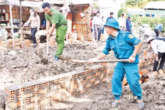 Lực lượng vũ trang cùng các đoàn thể chính trị xã Huyền Hội, huyện Càng Long, tỉnh Trà Vinh, hỗ trợ người dân xây nhà. (Ảnh: KHỞI - GIANG)