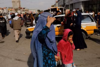 Một phụ nữ và trẻ em gái đi bộ trên một con phố ở Kabul, Afghanistan ngày 9/11/2022. (Ảnh: Reuters)