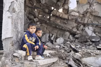 Hai em nhỏ bên một tòa nhà đổ nát ở Gaza. (Ảnh: Tân Hoa xã)