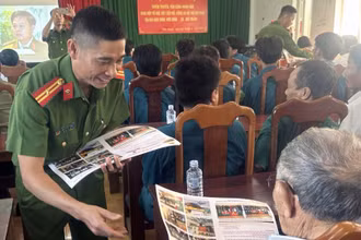 Công an tỉnh Đắk Nông phát tờ rơi tuyên truyền, phổ biến pháp luật cho người dân. (Ảnh: HOÀNG OANH)