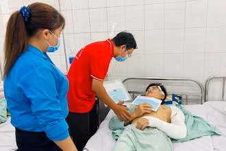 Đại diện Hội Chữ thập đỏ tỉnh Đồng Nai trao số tiền hỗ trợ công nhân bị thương.