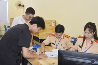 Cán bộ Phòng Cảnh sát Giao thông hướng dẫn học viên thủ tục thi.