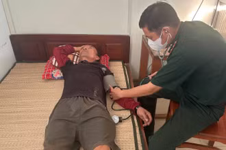 Bác sĩ Đồn Biên phòng Hàm Luông kiểm tra sức khỏe thuyền viên. (Ảnh: HOÀNG TRUNG)
