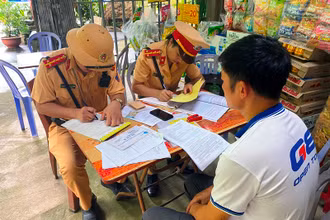 Cảnh sát giao thông Lào Cai lập biên bản xử phạt và tước giấy phép lái xe đối với tài xế và chủ doanh nghiệp "đội lốt" xe khách tuyến cố định. (Ảnh: QUỲNH TRANG)