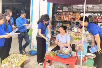 Ðoàn viên thanh niên Sở Thông tin và Truyền thông tỉnh Bắc Kạn hướng dẫn tiểu thương ở chợ sử dụng mã QR thanh toán trực tuyến. (Ảnh THU TRANG) 