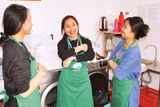 Lương Thị Kiều Thúy (người đứng giữa) trao đổi công việc cùng các đồng nghiệp. 