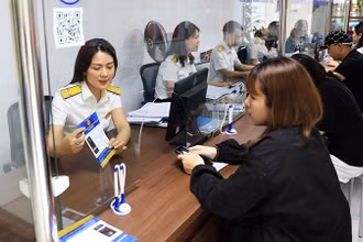Người dân giao dịch tại Chi cục Thuế quận Tây Hồ, Hà Nội. (Ảnh NGUYỄN QUANG) 