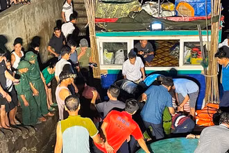 Các lực lượng chức năng và người dân khẩn trương đưa nạn nhân lên bờ.