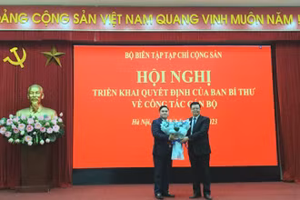 Đồng chí Mai Văn Chính trao quyết định và tặng hoa chúc mừng đồng chí Phạm Minh Tuấn được giao nhiệm vụ mới.