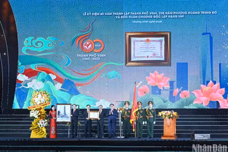 Chủ tịch Quốc hội Vương Đình Huệ trao Huân chương Độc lập hạng Nhì, tặng hoa, trao tặng bức tranh lưu niệm “Chủ tịch Hồ Chí Minh thăm công trường xây dựng Nhà máy điện Vinh (6/1957) cho Đảng bộ, chính quyền và nhân dân thành phố Vinh. (Ảnh: Duy Linh)