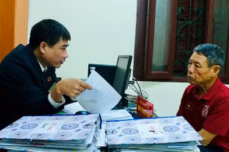 Cán bộ Tòa án nhân dân huyện Lý Nhân, tỉnh Hà Nam giải thích quy định pháp luật cho người dân. (Ảnh HẢI ĐĂNG)