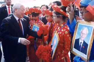 Tổng Bí thư Nguyễn Phú Trọng hỏi thăm các cháu thiếu nhi là con em người gốc Việt Nam tại Campuchia. (Ảnh: Hội Khmer-Việt Nam cung cấp)