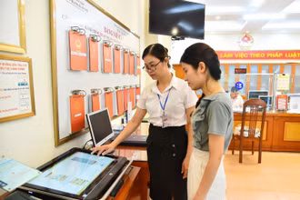 Cán bộ Ủy ban nhân dân phường Thanh Xuân Nam (quận Thanh Xuân, Hà Nội) hướng dẫn người dân thực hiện thủ tục hành chính trên môi trường mạng. Ảnh: Thuỷ Nguyên.