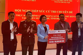 Bà Phạm Thị Thanh Mai, Phó trưởng đoàn chuyên trách Đoàn Đại biểu Quốc hội thành phố Hà Nội, trao kinh phí mua áo ấm tặng học sinh nghèo huyện Mường Nhé.