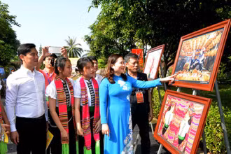 Các đại biểu và học sinh tham quan triển lãm ảnh.