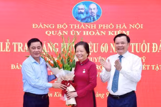 Chủ nhiệm Ủy ban Kiểm tra Trung ương Trần Cẩm Tú và Bí thư Thành ủy Hà Nội Đinh Tiến Dũng tặng hoa chúc mừng đồng chí Nguyễn Thị Xuân Mỹ.