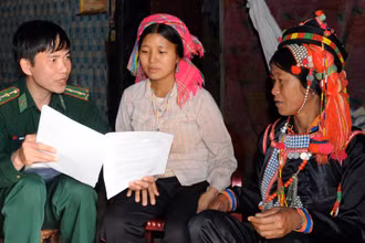 Cán bộ Ðồn Biên phòng Ka Lăng (Lai Châu) đến nhà người dân tuyên truyền phòng chống mua bán người. (Ảnh LÂM THANH) 