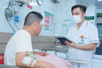 Nhân viên y tế Bệnh viện Bạch Mai sử dụng bệnh án điện tử trong quá trình thăm khám cho bệnh nhân.