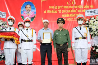Thiếu tướng Lê Văn Tuyến trao quyết định của Bộ trưởng Công an cho thân nhân liệt sĩ-Trung tá Nguyễn Khắc Thường.