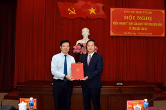 Đồng chí Mai Văn Chính, Ủy viên Trung ương Đảng, Phó Trưởng Ban Thường trực Ban Tổ chức Trung ương (bên trái) trao Quyết định của Ban Bí thư cho đồng chí Đoàn Anh Dũng.