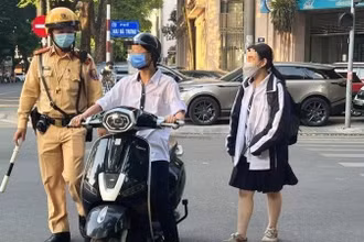 Lực lượng cảnh sát giao thông kiểm tra, xử lý học sinh vi phạm an toàn giao thông của học sinh. (Ảnh: Báo Nhân Dân)