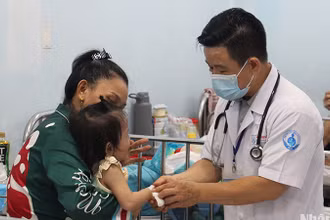 Bác sĩ Bệnh viện Nhi đồng 1 đang khám cho trẻ mắc tay chân miệng (Ảnh: Thế Anh)